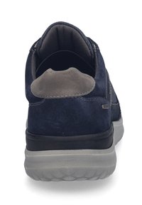 Scarpe atletiche in suede blu navy con un accento in suede grigio sul tallone, interno imbottito e suola in gomma testurizzata con battistrada visibile.