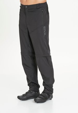 Zwarte outdoor broek van een lichtgewicht, duurzaam materiaal. Voorzien van ritszakken, een verstelbare taille en ergonomisch gevormde knieën voor optimale bewegingsvrijheid.