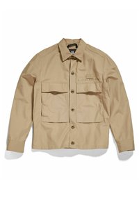 Giacca beige in tessuto leggero con chiusura a bottoni, tasche sul petto e colletto ripiegato. Presenta un branding discreto nell'area delle tasche.