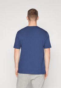 Kurzes, ärmelloses navy-blaues T-Shirt aus Baumwolle; verfügt über einen klassischen Rundhalsausschnitt und eine lockere Passform; glatte Textur ohne sichtbare Muster.