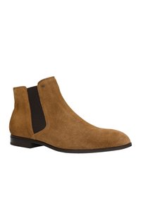 Sandfarbene Wildleder-Stiefelette mit elastischen Seitenpaneelen, sanften Kurven, runder Zehenpartie und niedrigem, gestapeltem Absatz. Verfügt über eine Naht entlang der Ränder.