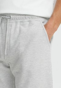 Lysegrå sweatpants lavet af blødt bomuldsblandingstof, med en elastisk talje, snoretræk og sidelommer.