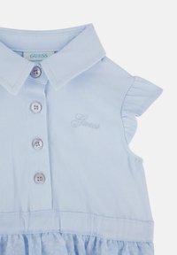 Abito senza maniche azzurro chiaro con colletto, chiusura a bottone frontale, spalle arricciate e sovrapposizione di gonna a motivo floreale. Logo ricamato.