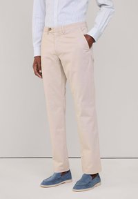 Chino beige in twill di cotone, con vestibilità standard, tasche laterali e chiusura con un singolo bottone in vita.