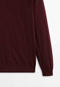 Bordeaux gebreide trui met lange mouwen, ronde halslijn en een geribbelde zoom. De textuur lijkt glad en licht, geschikt voor het dragen in lagen.