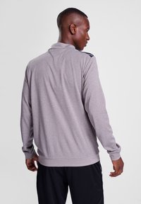 Grå langærmet pullover med krave, med mørke skulderdetaljer og ribbede manchetter. Glat tekstur, afslappet design og løs pasform.
