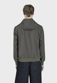 Maslinasto zelena kapuljača s glatkom teksturom, rebrastim manžetama i donjim dijelom, te opuštenim krojem. Sadrži jednostavan, sportski dizajn.