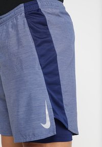 Herridrottsshorts i ljusblått med mörkblå sidopanel, tillverkade av lätt material. Har en vit Nike-logga.