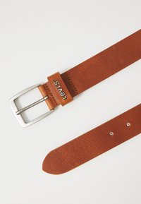 Hnědý kožený opasek se stříbrnou obdélníkovou sponou, s vyraženým logem "Levi's" a viditelným prošíváním podél okrajů.