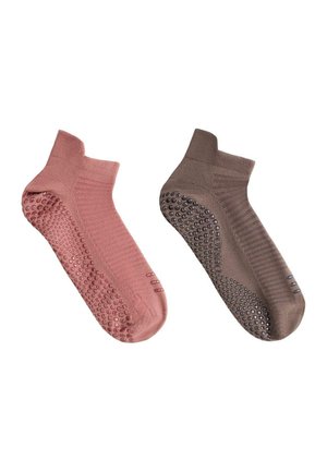 Paar knöchellange rutschfeste Socken, eine pink und eine braun, jeweils mit Gummipunkten an Sohle und Zehen.