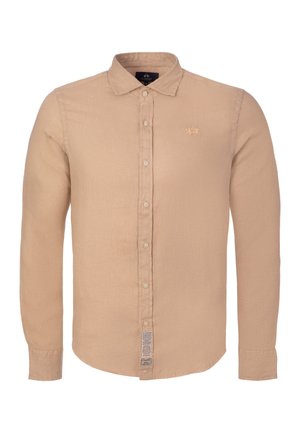 Beige pitkähihainen kauluksellinen napillinen paita, pieni brodeerattu logo rinnassa ja etiketti helman lähellä nappilistassa.