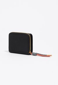Kompaktowy czarny portfel na zamek błyskawiczny z złotym suwakiem i przymocowanym warkoczykowym uchwytem w odcieniach szaro-pomarańczowym.