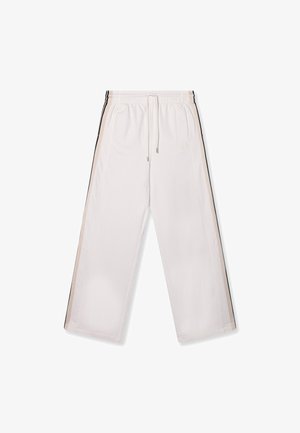 White athletic pants made of lightweight fabric, featuring an elastic waistband, drawstring, and contrasting black and beige side stripes.