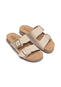 Beige slip-on sandals with two wide straps, gold buckles, and a cork sole. Soft suede-like upper with a textured footbed.