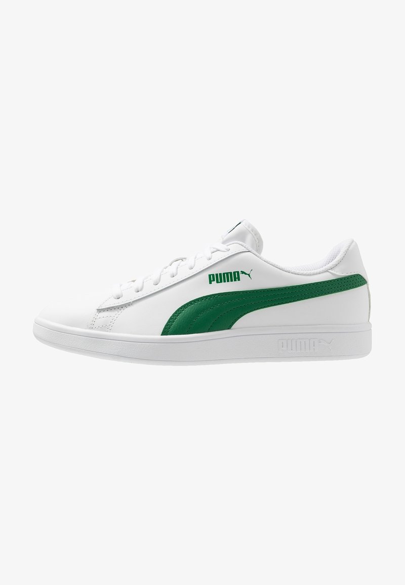 Baskets basses blanches Puma avec un détail de bande verte et le logo Puma sur le côté et le talon, semelle blanche plate, et design à lacets.