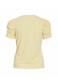 Krótka żółta bluzka o teksturowanej powierzchni z bufkami na rękawach, widoczna od tyłu.