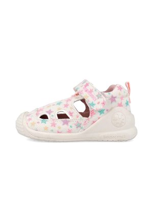 Sandalia blanca para niño pequeño con patrón de estrellas multicolores, cierre de velcro, protector de goma en la punta y suela beige con la etiqueta "biomecanics".