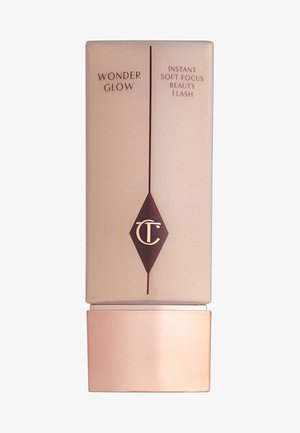 Bottiglia cosmetica rettangolare beige con una base bronzea lucida. Presenta testo marrone scuro e un logo a forma di diamante. L'etichetta riporta la dicitura "Wonder Glow."
