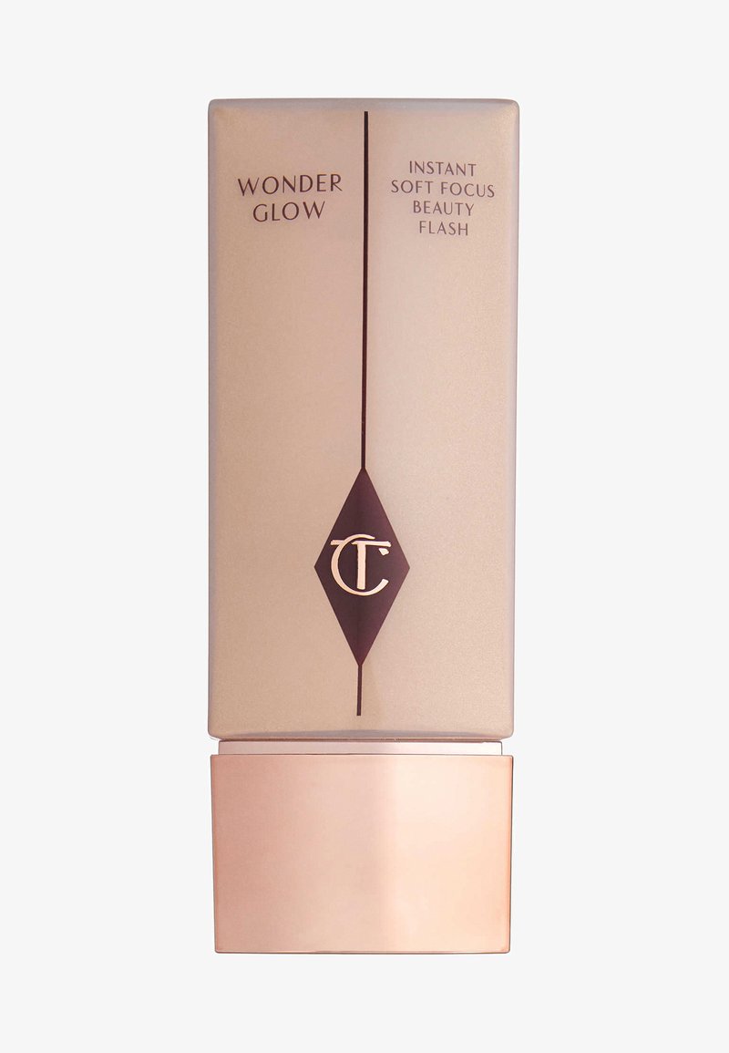 Rectangular beige cosmetic bottle with a glossy bronze base. Features dark brown text and a diamond logo. Label states "Wonder Glow."