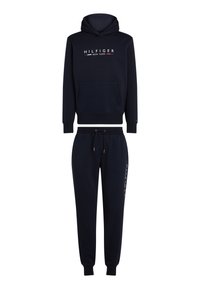 Tumši zils kapuci jaka un atbilstošas sporta bikses. Ir priekšējā kabata, elastīgas manžetes un baltas, sarkanas un zilas krāsas logotips sānos.