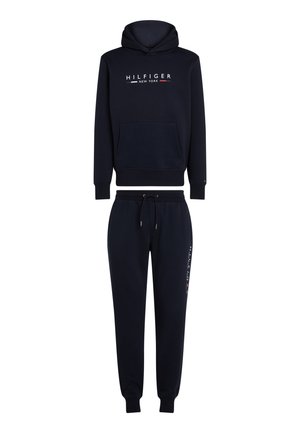 - Sweat-shirt à capuche bleu marine et pantalon de survêtement assorti. Comprend une poche avant, des poignets élastiques, et un branding en blanc, rouge et bleu sur le côté.