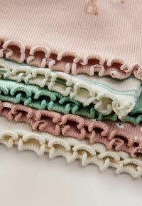 Päť vrstiev ryhovanej tkaniny v pastelových farbách: svetloružová, svetlozelená, krémová s pruhmi, jemná mäta a poprášená ruža, pričom každá má volánkové okraje.