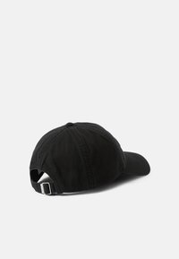 Cappellino da baseball in cotone nero con visiera curva, cinturino regolabile sul retro e cuciture visibili per una maggiore texture.