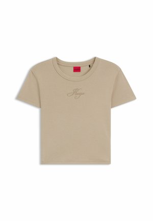 T-shirt court beige à manches courtes, col rond, avec un logo "Hugo" brodé discret sur la poitrine, étiquette intérieure rouge.