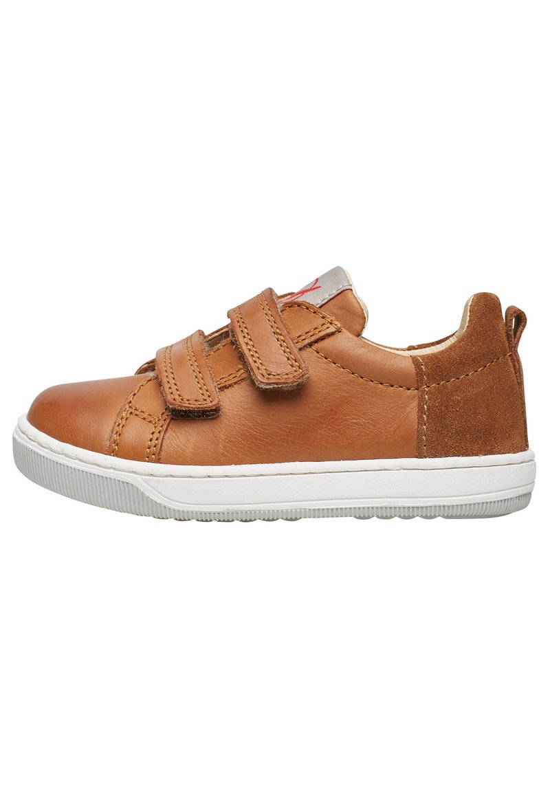 Sneaker in pelle color cuoio con due fasce in Velcro, una suola in gomma bianca e un piccolo accentro rosso sulla linguetta. Materiali lisci e texturizzati.