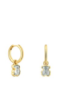 Goldfarbene Creolen mit einem Gummibär-Anhänger, der einen hellgrauen, strukturierten Stein in Bärenform zeigt, mit glattem Metallfinish.