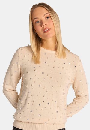 Suéter beige con textura de punto, adornado con perlas y piedras de strass dispersas. Cuello redondo clásico y dobladillo acanalado.