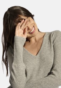 Maglione grigio chiaro a V in morbido tessuto a maglia, con polsini a costine e una vestibilità rilassata, che migliora il comfort e lo stile.