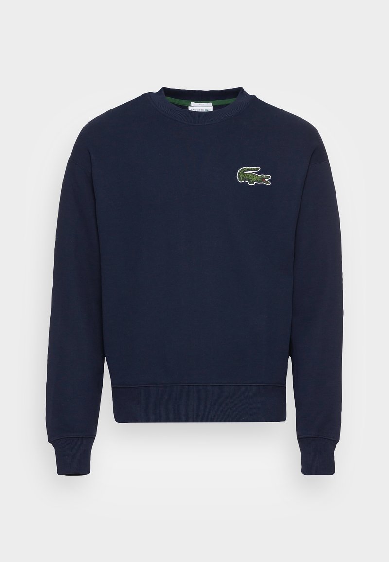 Sweat-shirt bleu marine à col rond avec manches longues et petit logo crocodile vert sur le côté gauche de la poitrine.