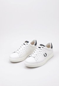 Sneakers bianchi in pelle con accentuazioni blu sul tallone, punta tonda, suola piatta bianca e lacci bianchi. Presentano un dettaglio del logo sul lato.