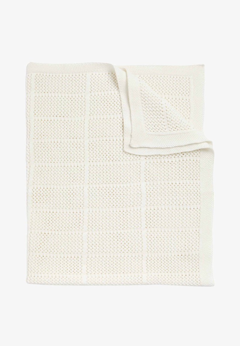 Bílý pletený přehoz s texturovaným mřížkovým vzorem. Měkký, prodyšný materiál s jemným leskem a upravenými okraji.