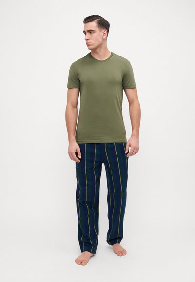 T-shirt in cotone verde oliva abbinato a pantaloni da pigiama a righe blu navy con linee gialle. Taglio comodo e design casual con maniche corte.
