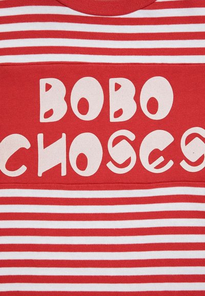 Crvena pamučna majica s bijelim horizontalnim prugama i velikim grafičkim otiskom u razigranom fontu koji glasi "BOBO CHOSES."