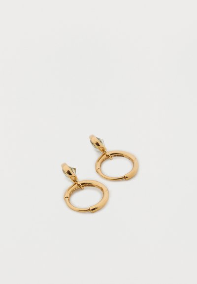 Arany fém karika fülbevalók sima, polírozott felülettel. Biztonságos zsanéros csattal és egy kis, geometriai díszítéssel a tetején.