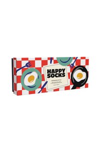 Pudełko prezentowe z czerwono-białą kratką, zielone talerze z jajkami, czarna patelnia oraz logo "HAPPY SOCKS" z przodu.