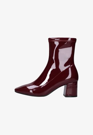 Stivaletto alla caviglia bordeaux in vernice con punta affilata e tacco a blocco. Presenta una finitura lucida elegante e dettagli in elastico sul polsino.