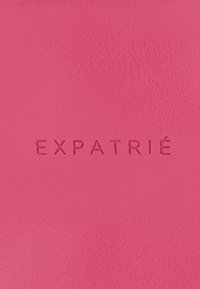 Rózsaszín bőrfelület, amelyen a "EXPATRIÉ" felirat modern betűtípussal van bemélyítve. A textúra sima, enyhe fényességgel.
