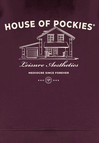 Vinrød genser med et hvitt motiv av et hus med teksten "HOUSE OF POCKIES", "Leisure Aesthetics" og "MEDIOCRE SINCE FOREVER".