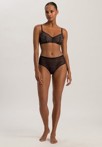 Musta pitsialusvaatesetti sisältää geometrisilla kuvioilla koristellun rintaliivitopin ja korkeavyötäröiset alushousut, jotka esittelevät yksityiskohtaisia ja teksturoituja yksityiskohtia.