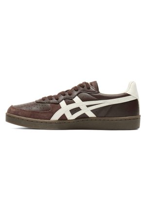 Low-profile brown sneaker with white side stripes, suede detailing, and brown laces on a dark rubber sole against a white background.