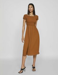 Rochie maronie, de lungime medie, dintr-un material ușor, cu un corset cu elastice și mâneci scurte tip puff, asortată cu sandale negre cu toc.