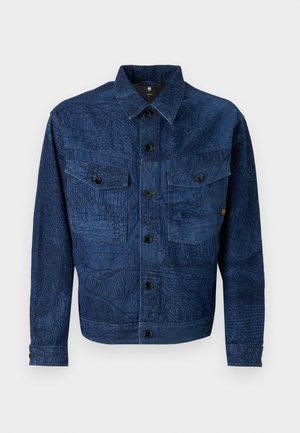 Veste en jean bleu foncé avec des motifs texturés complexes, dotée d'une fermeture à boutons, de deux poches poitrine et d'un col.