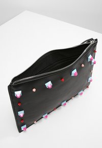 Černé kožené psaníčko se zipovým uzávěrem, zdobené barevnými geometrickými cvoky v odstínech růžové, modré a červené. Hladká textura.