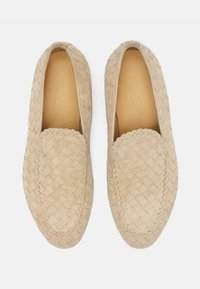 Bež, pletene cipele za slip-on s okruglim prstom, s teksturiranom površinom i šivenim detaljima duž rubova. Glatka podstava.