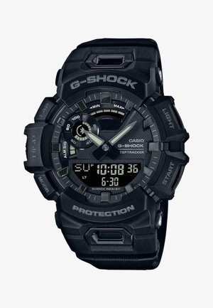 Casio G-Shock kell rugged musta vaikest endast, suure digitaalse ekraaniga, analoog näidikute ja tekstuuriga rihmaga. Omab šoki vastupidavust.