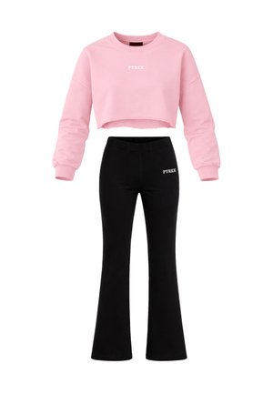 Felpa corta rosa con scritta "PYREX" e pantaloni a zampa neri con logo "PYREX" sull'anca sinistra, mostrati su sfondo bianco.